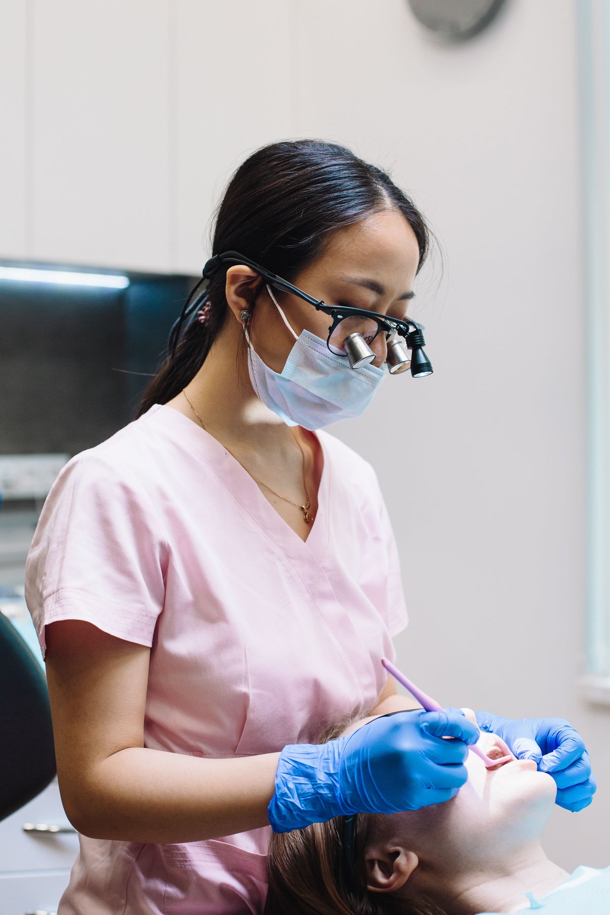 Dental professional wearing loupes while working with a patient